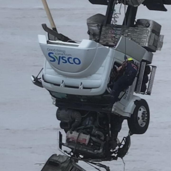 Crews pull driver from semi dangling from 2nd Street Bridge